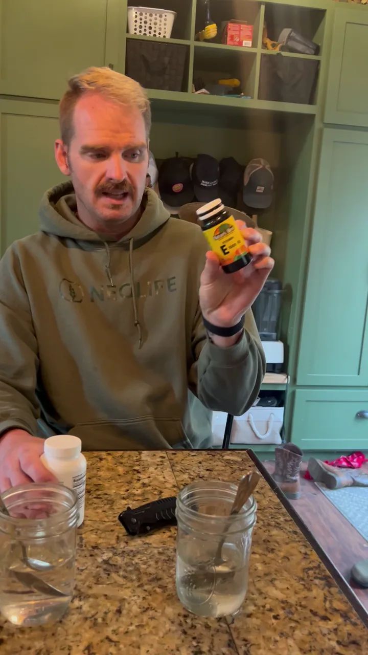 Joseph holding a NeoLife vitamin E bottle at his kitchen counter